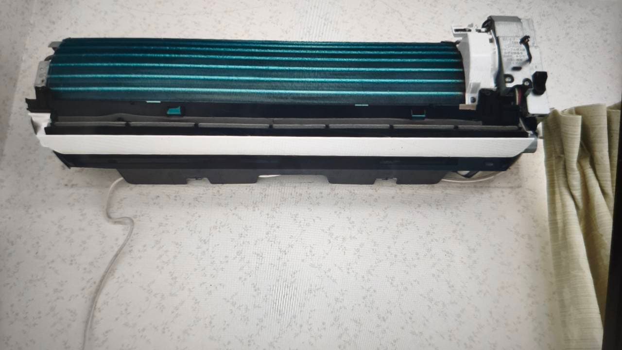 Full wall-mounted indoor air-conditioner with the front cover removed and the right-side piping area visible