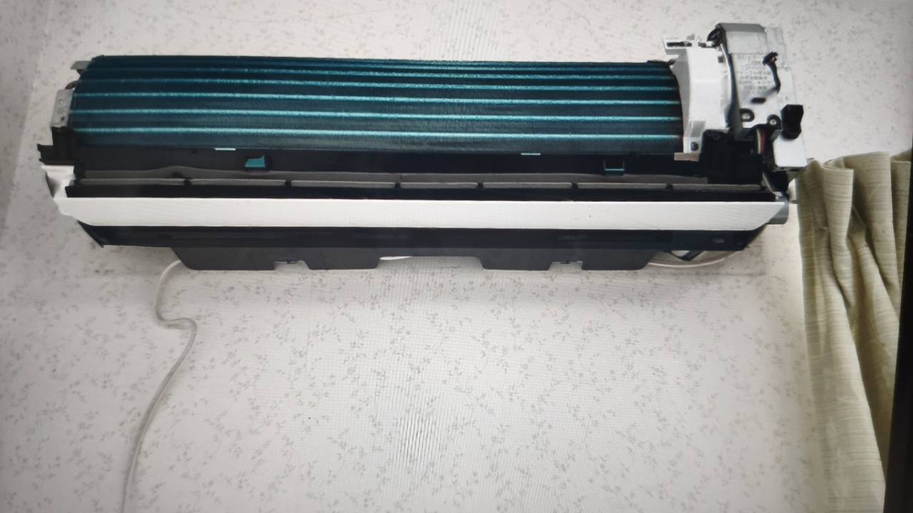 前面カバーを外した壁掛けエアコンの室内機全体と右側の配管まわり